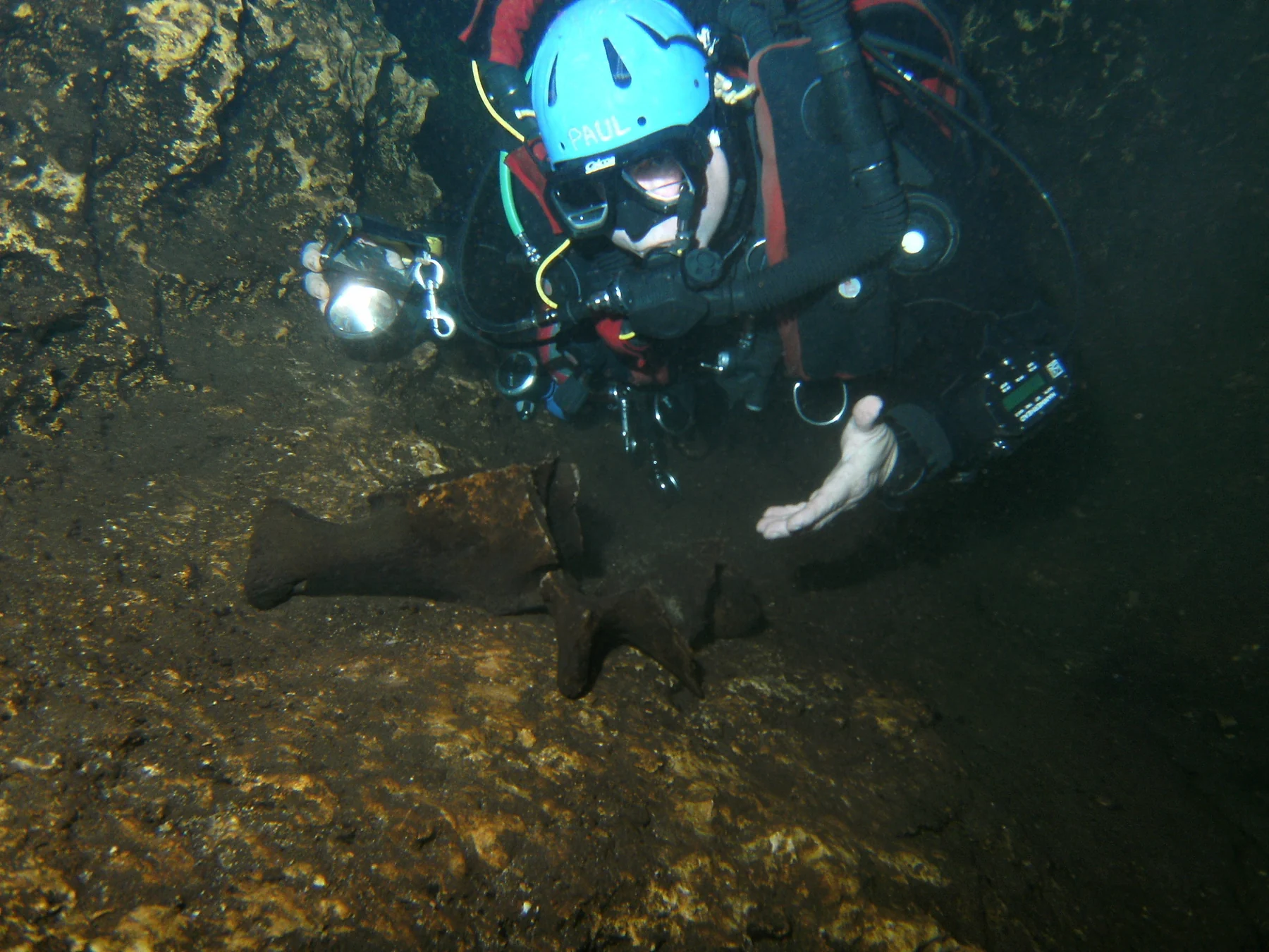 Paul Heinerth cave diving beside whale bones on the floor of Devil's Ear cave system